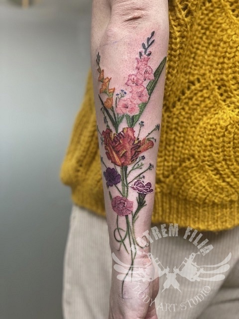 Bloemen op onderarm in kleur Tattoeages