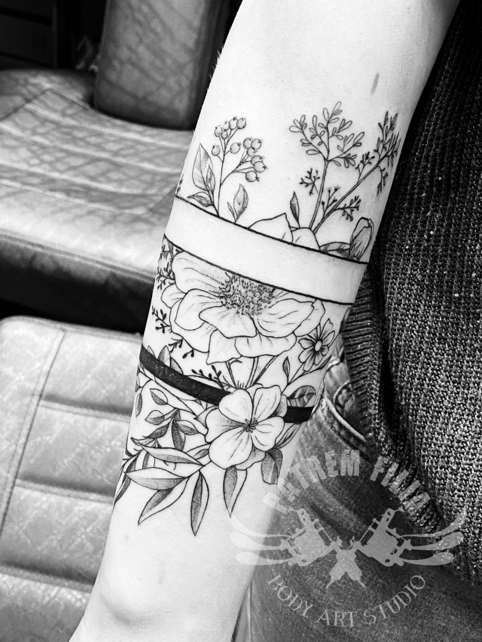 bloemen op onderarm met banden Tattoeages