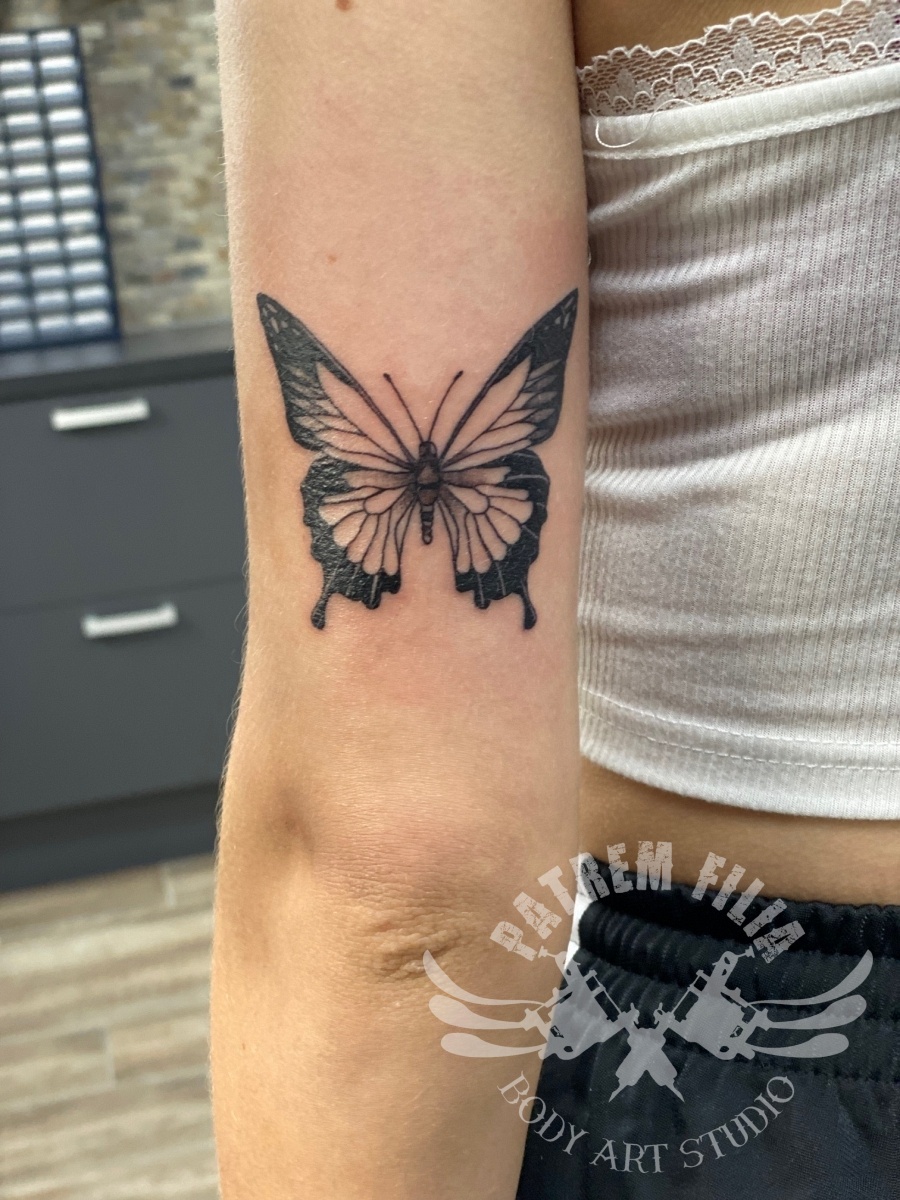 Vlinder op achterkant bovenarm Tattoeages