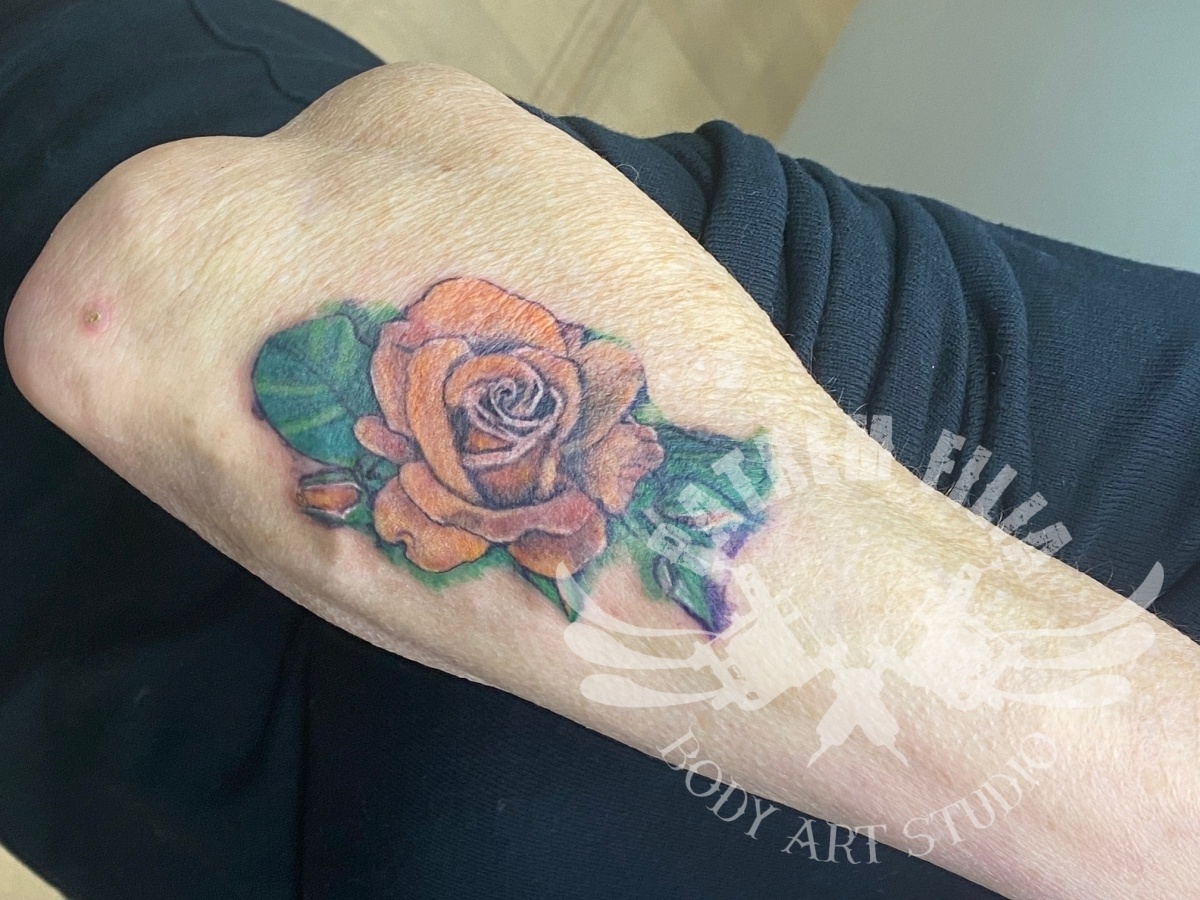 watercolor roos op onderarm Tattoeages