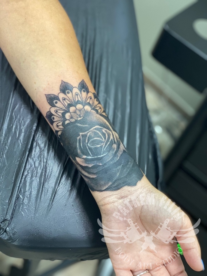 zwarte roos op pols Tattoeages