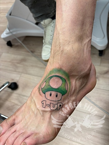 1-UP paddenstoel tattoo — gaming nostalgie op de enkel