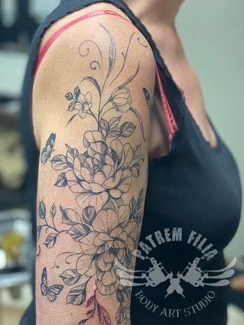 bovenarm met bloemen en vlinders