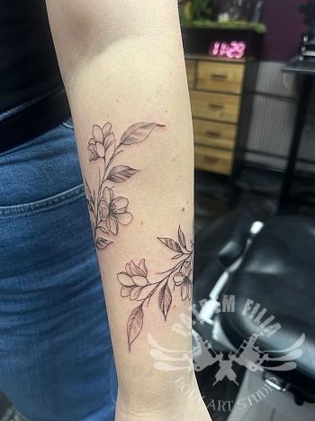Fijne botanische fine line tattoo op de onderarm