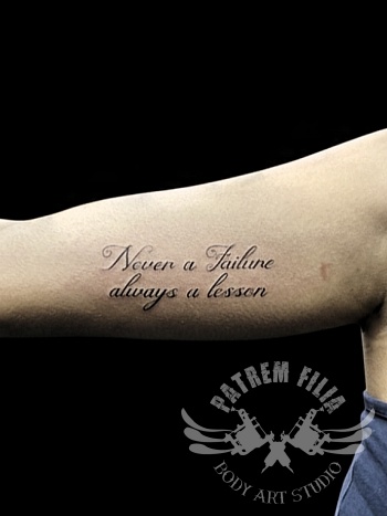 Fijne script tattoo met quote op de bovenarm