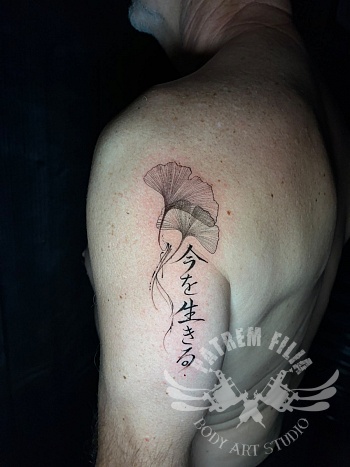 Fine-line Ginkgo blad tattoo met Japanse kalligrafie