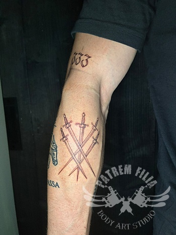 Fine line tattoo van drie gekruiste zwaarden op onderarm