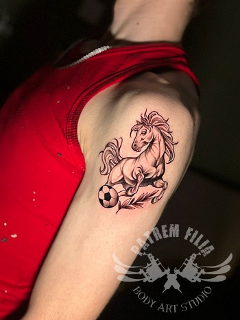 Gestileerde tattoo van een springend paard met voetbalaccent.