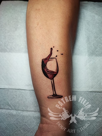 glaasje rode wijn op onderarm
