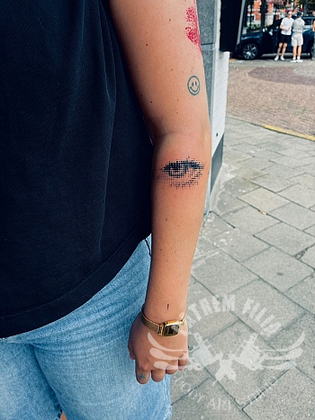 Halftone oog tattoo op de onderarm