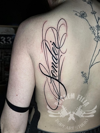 Infinity naamtattoo op de rug — sierlijke lijnen met persoonlijke betekenis