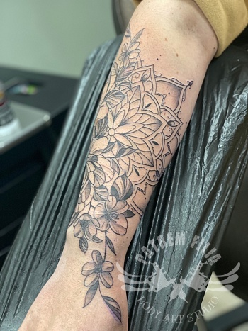 Mandala met bloemen op onderarm