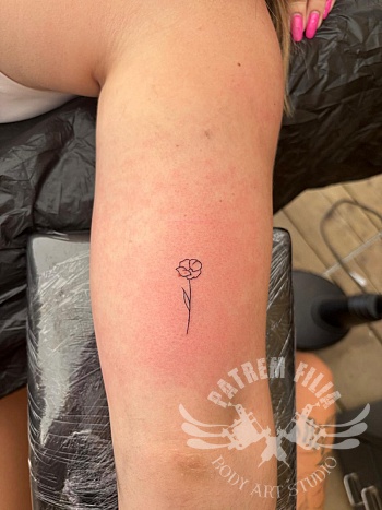 Minimalistische bloem - bovenarm tattoo