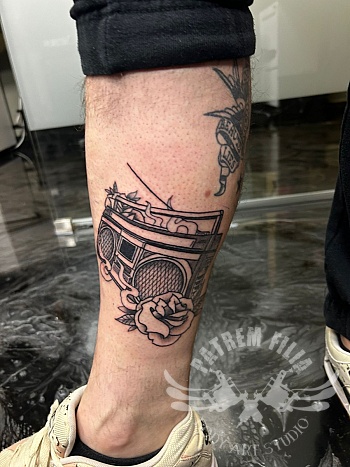 Old school boombox tattoo met roos op het onderbeen