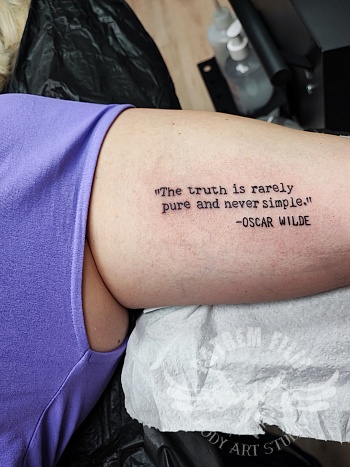 Oscar Wilde text op bovenarm