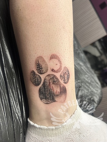 Pootafdruk tattoo met natuur landschap op de enkel