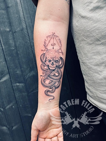 Realistische onderarm tattoo met schedel, slang en magische symboliek
