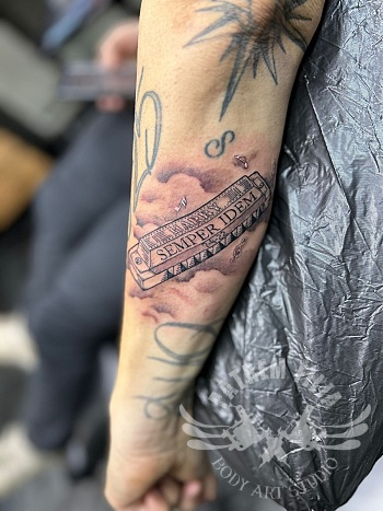 Realistische tattoo met mondharmonica en wolkenpartij