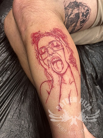 Red ink portret tattoo met expressieve stijl op onderbeen