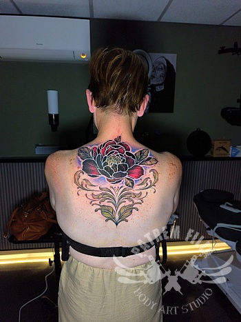 Cover rugtattoo met pioenroos — kleur, elegantie en symmetrie