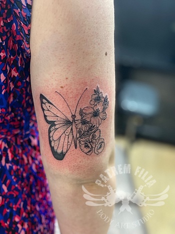 Vlinder met bloemen op bovenarm