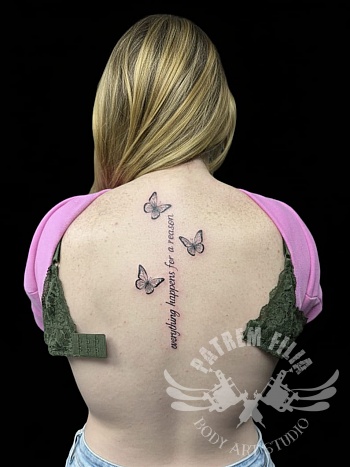 Vlinder tattoo met quote op de rug