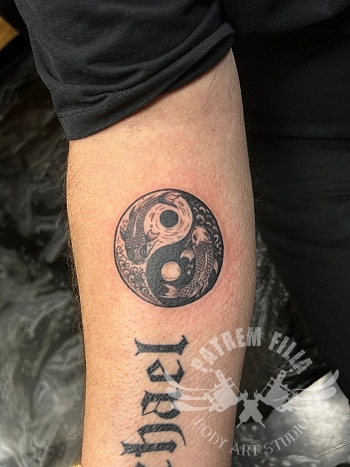 Yin yang tattoo met koi vissen op de onderarm